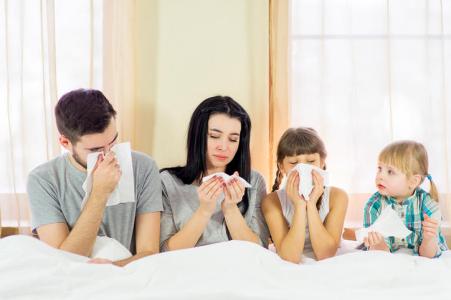 Sick Family Lying In Bed At Home